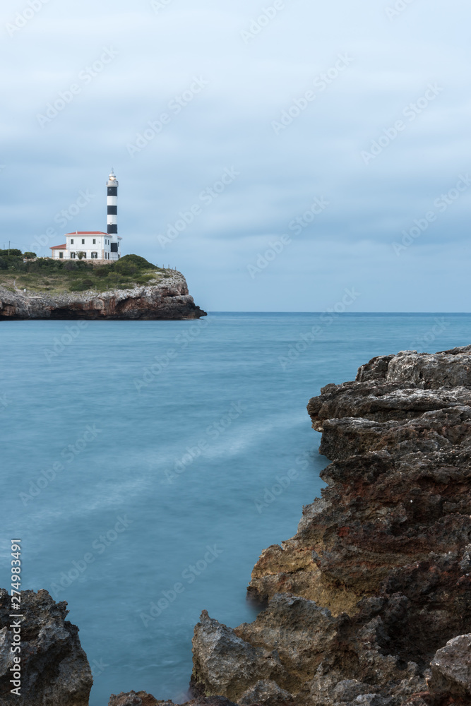The lighthouse of Portocolom on a cloudy morning, Mallorca, Spain - June 08, 2019