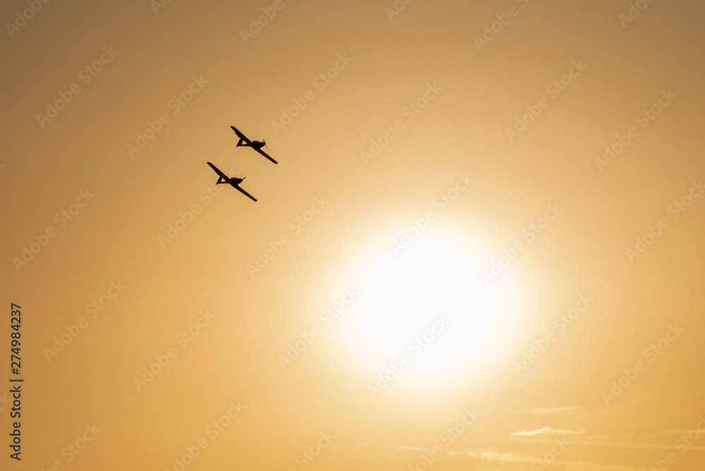 Airplanes flying at sunset. Orange sky background Airplanes flying at sunset. Orange sky background