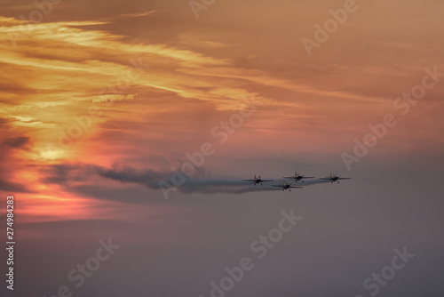 Airplanes flying at sunset. Orange sky background