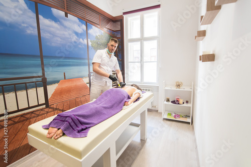 Schilderij op canvas Young woman laying down at the massage table and doing hijama treatment