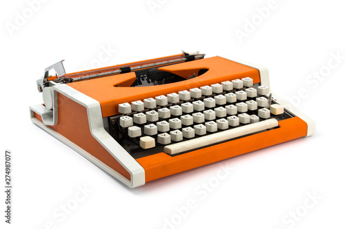 Old orange typewriter isolated on white background.