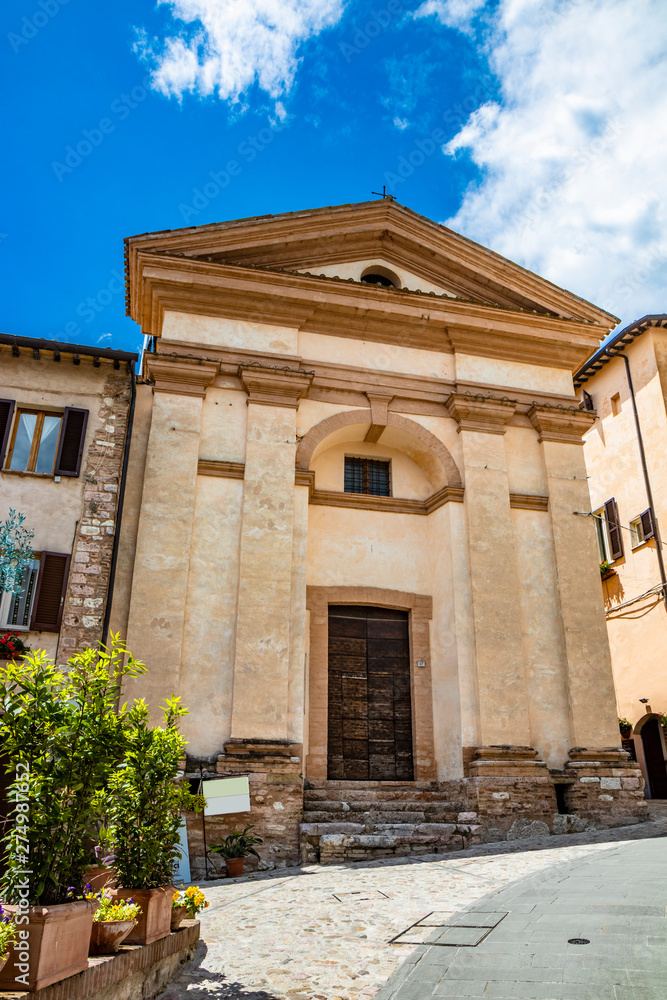 June 1, 2019 - Spello, Perugia, Umbria, Italy - A church with a tympanum and a wooden door in the historic center.