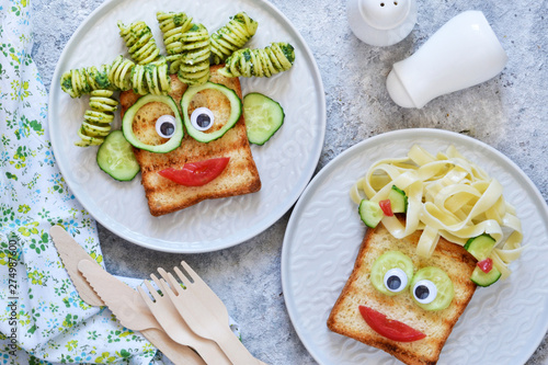 Lunch for children. Pasta with sandwiches and vegetables. Cheerful face.