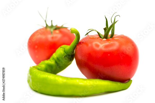ripe fresh organic tomatoes in drops of dew and green hot chili pepper isolated on white background