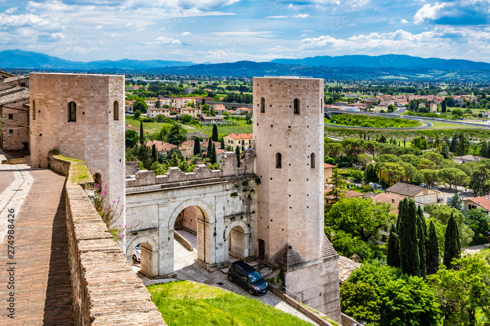 The Porta di Venere, from the Roman era, made of white travertine, with its three arches and the two towers of Properzio. In Spello, province of Perugia, Umbria, Italy.