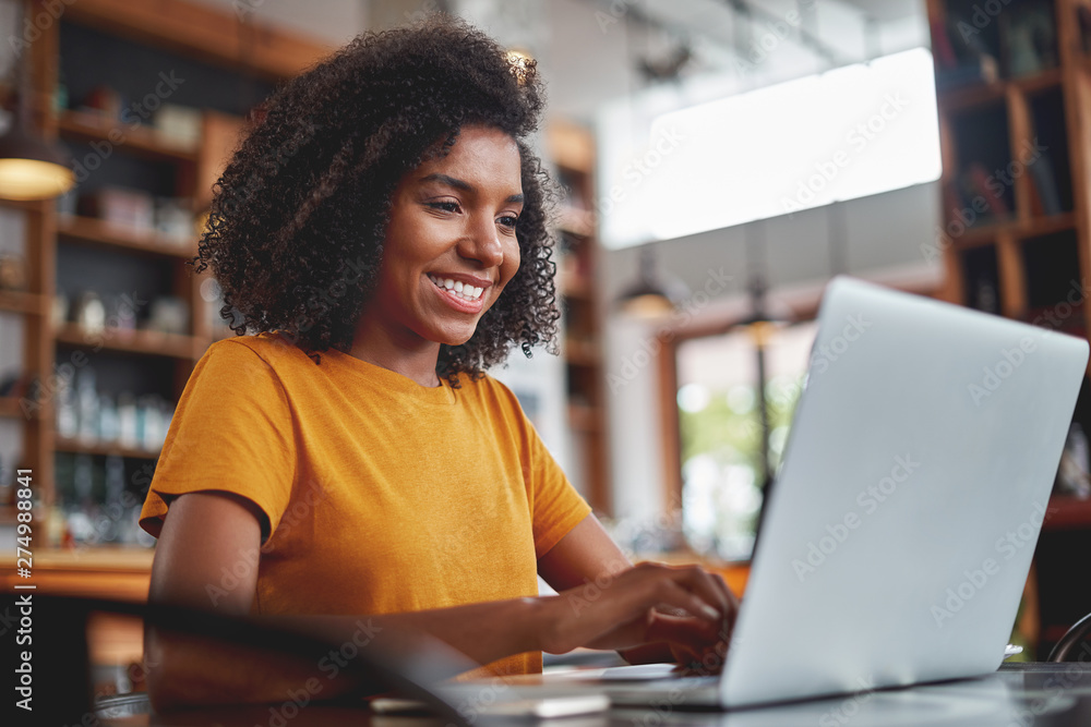 Happy woman using laptop in cafe