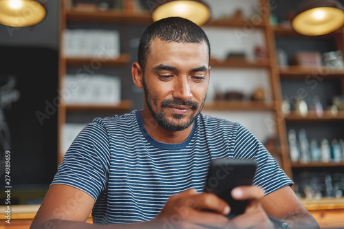 Young man using smartphone in café