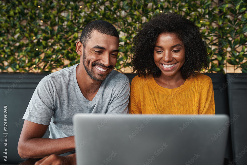 Smiling young couple using laptop Smiling young couple using laptop