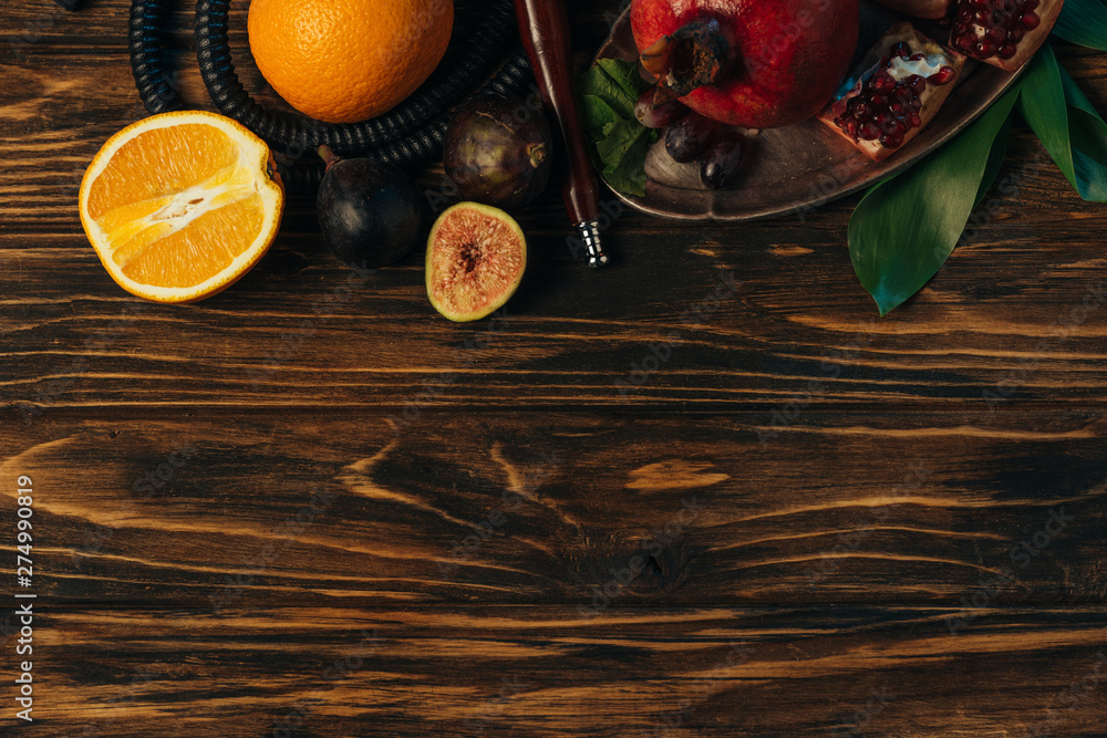top view of fresh exotic fruits and hookah on wooden surface