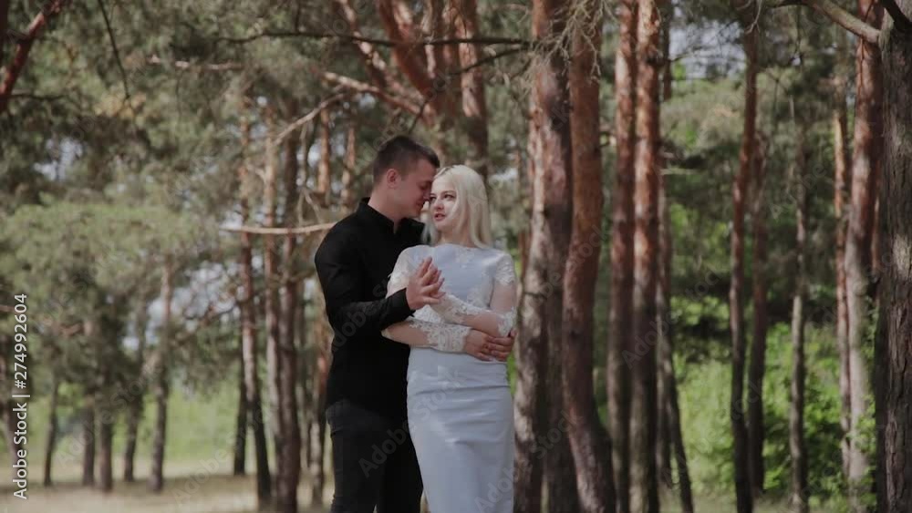 Beautiful and happy loving couple are tenderly embracing in the forest. Beautiful and happy loving couple are tenderly embracing in the forest.