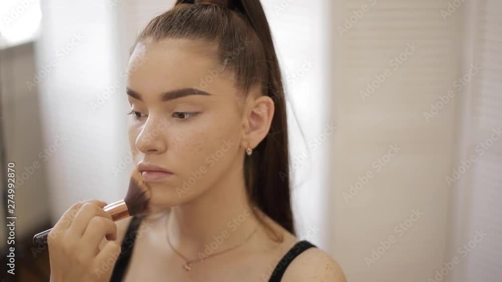 Makeup artist work in her beauty studio. Woman applying by professional make up master. Beautiful make up artist make a makeup for redhead model with freckles. She use a palette Makeup artist work in her beauty studio. Woman applying by professional make up master. Beautiful make up artist make a makeup for redhead model with freckles. She use a palette