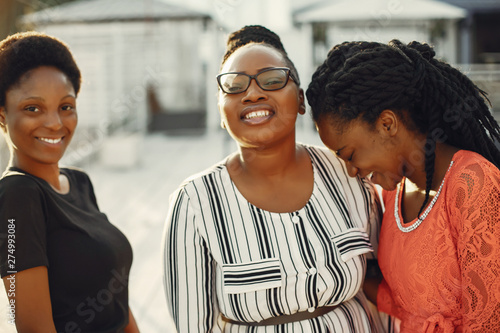Three black girls. Women in a summer park. Friends have fun