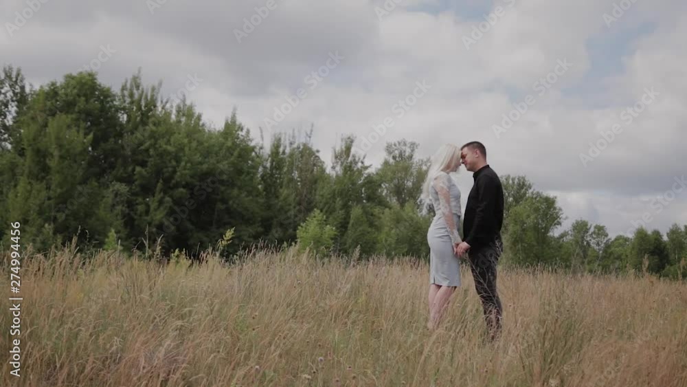 Happy couple in love standing on the field holding hands. Happy couple in love standing on the field holding hands.