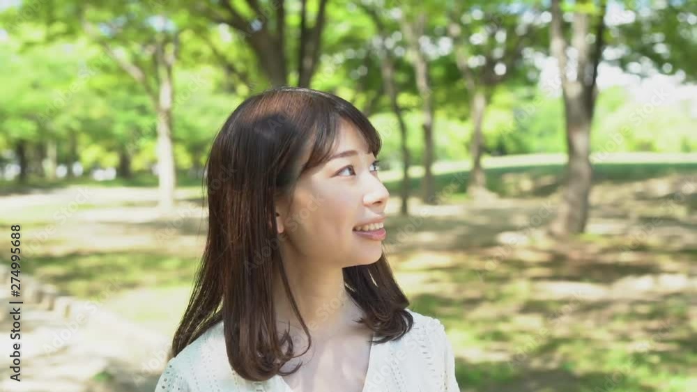 公園で散歩をする笑顔の女性 スローモーション 公園で散歩をする笑顔の女性 スローモーション