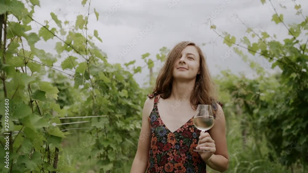 Happy woman walking free on vineyard by grapevines having fun on wine tour in wine region visiting a winery. Woman on holiday or wine tasting experience in summer valley. SLOW MOTION. Happy woman walking free on vineyard by grapevines having fun on wine tour in wine region visiting a winery. Woman on holiday or wine tasting experience in summer valley. SLOW MOTION.