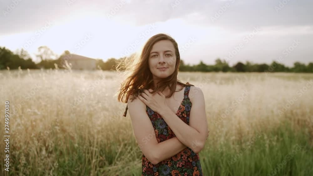 Woman looking at camera and smiling at fields with high grass. Slowmotion Woman looking at camera and smiling at fields with high grass. Slowmotion