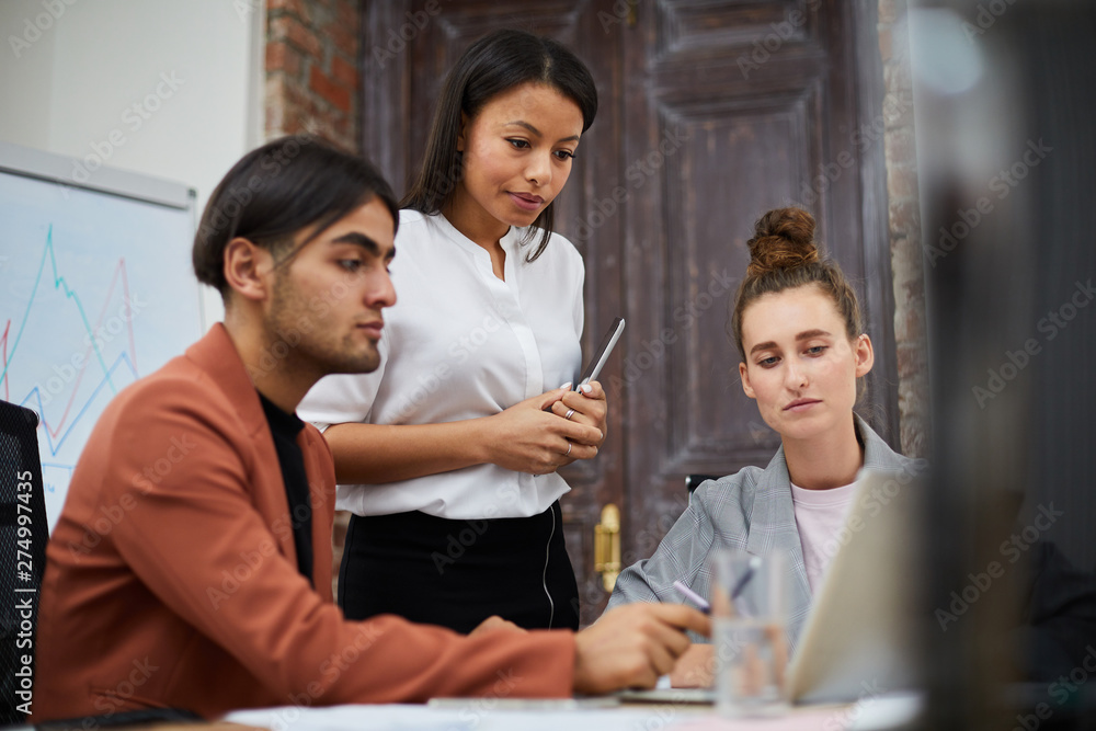 Portrait of multi-ethnic business team using laptop together while collaborating on startup project, copy space Portrait of multi-ethnic business team using laptop together while collaborating on startup project, copy space