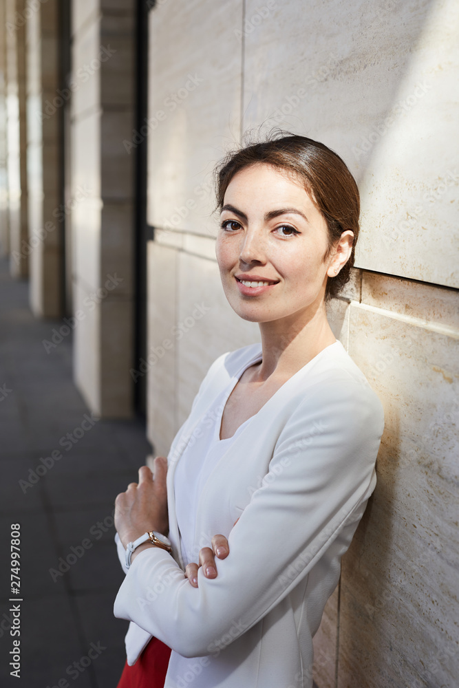 Waist up portrait of elegant businesswoman looking at camera while posing outdoors standing with arms crossed Waist up portrait of elegant businesswoman looking at camera while posing outdoors standing with arms crossed