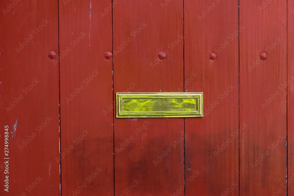 Old style brass mail slot on a wooden gate Old style brass mail slot on a wooden gate