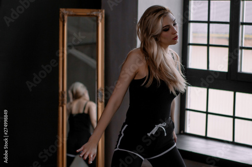 Beautiful slim young female modern jazz contemporary style ballet dancert on a loft studio background
