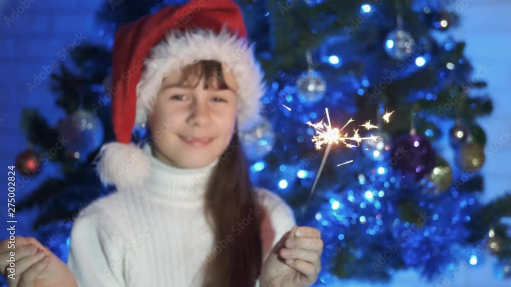 Sparkler New Year party. Cheerful little girl in santa claus hat with sparklers. Sparkler New Year party. Cheerful little girl in santa claus hat with sparklers.