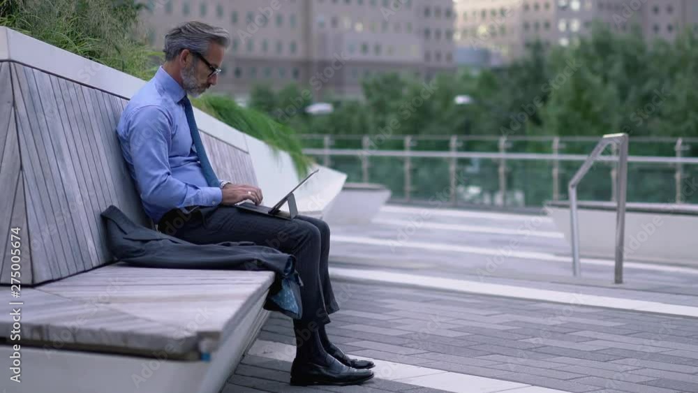 Time lapse effect of male employee in blue shirt working online with financial news on modern tablet with 4G internet sitting on bench in city, mature office worker updating profile on touch pad Time lapse effect of male employee in blue shirt working online with financial news on modern tablet with 4G internet sitting on bench in city, mature office worker updating profile on touch pad