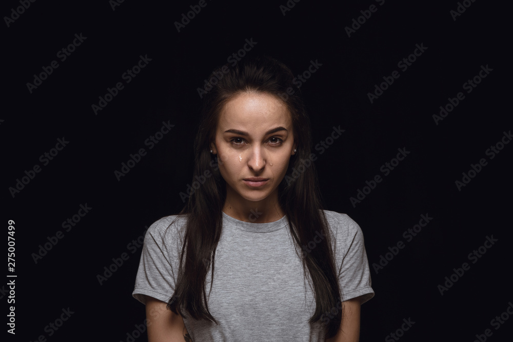 Close up portrait of young woman isolated on black studio background. Photoshot of real emotions of female model. Crying, sad, dreary and hopeless. Facial expression, human emotions concept. Close up portrait of young woman isolated on black studio background. Photoshot of real emotions of female model. Crying, sad, dreary and hopeless. Facial expression, human emotions concept.