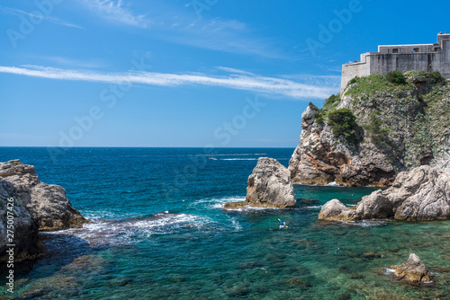 Kayakers or canoeists in the sea by the city walls and old fort Lawrence in Dubrovnik