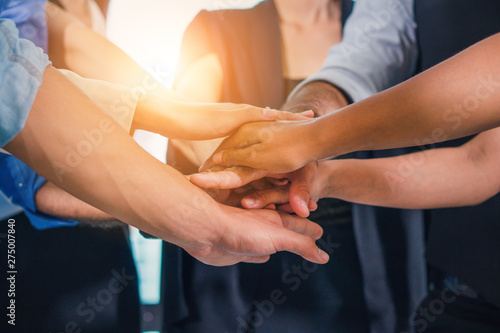business people stacking hands together to cheer up team spirit