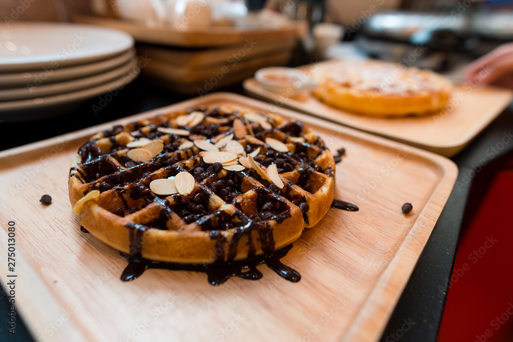 waffles with chocolate sauce on wooden plate waffles with chocolate sauce on wooden plate