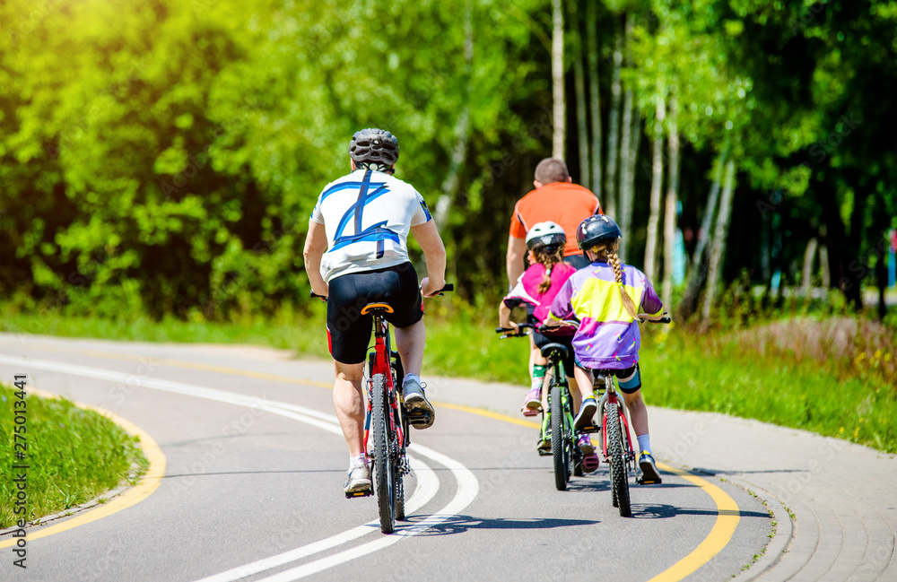 Obraz premium Cyclists ride on the bike path in the city Park