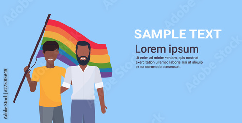 couple gays holding lgbt rainbow flag love parade pride festival concept two smiling guys embracing male cartoon characters portrait horizontal copy space flat