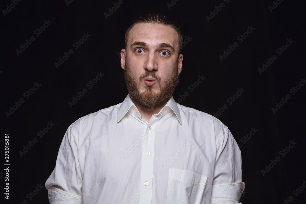 Close up portrait of young man isolated on black studio background. Photoshot of real emotions of male model. Wondering, exciting and astonished. Facial expression, human emotions concept. Close up portrait of young man isolated on black studio background. Photoshot of real emotions of male model. Wondering, exciting and astonished. Facial expression, human emotions concept.