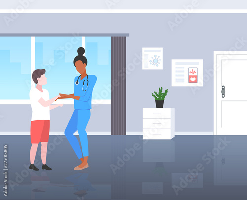 doctor pediatrician reassuring boy patient woman in uniform examining male kid medical consultation healthcare concept modern pediatric department hospital room interior full length flat