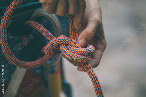 Rock climber tying a safety knot.