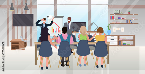 mix race businesspeople conference meeting presentation flip chart decreasing graph negative trend concept colleagues brainstorming teamwork modern office interior full length flat horizontal