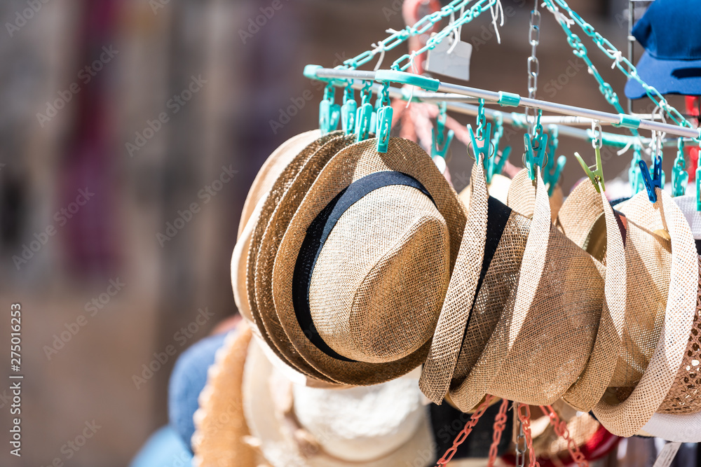 Siena old town in Tuscany, Italy with market outside in famous city during day shopping store and hats hanging on display