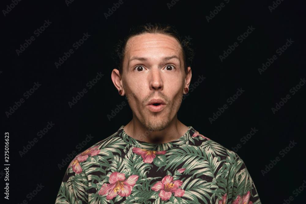 Close up portrait of young man isolated on black studio background. Photoshot of real emotions of male model. Wondering, exciting and astonished. Facial expression, human emotions concept. Close up portrait of young man isolated on black studio background. Photoshot of real emotions of male model. Wondering, exciting and astonished. Facial expression, human emotions concept.