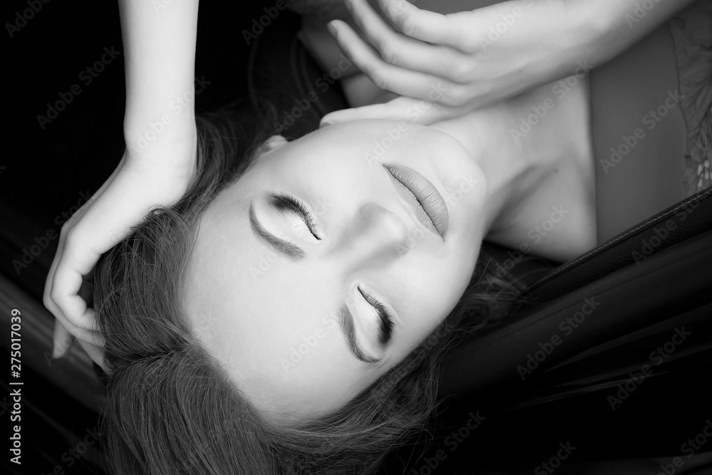Glamorous young woman with professional make-up and hair style posing in the car interior top view black and white image. Glamorous young woman with professional make-up and hair style posing in the car interior top view black and white image.