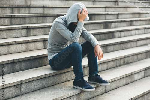 Foto Upset woman sitting alone in city stairs