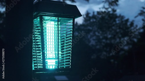 Close up of a bug zapper against night sky. Flat plane. Blurred effects in the background
