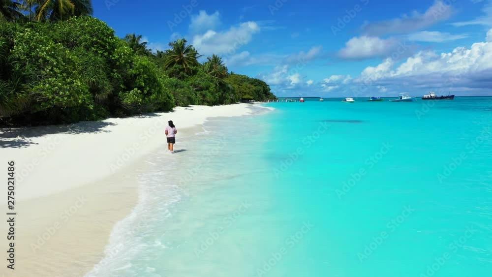 young woman tourist walking barefoot on white sand beach partially in the turquoise water,Exotic Island with crystal clear sea, preserved nature and floating boats young woman tourist walking barefoot on white sand beach partially in the turquoise water,Exotic Island with crystal clear sea, preserved nature and floating boats