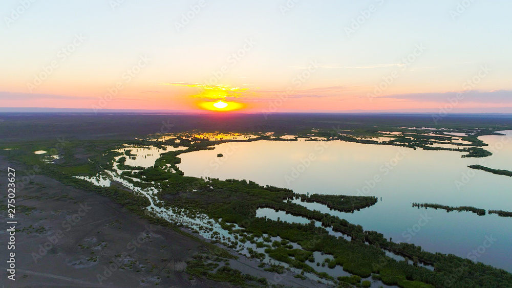 Obraz premium Aerial view over The Ailik Lake during sunset with beautiful colors and reflection from the sun. The Ailik or Aylik lake is a lake in Xinjiang Uighur Autonomous Region of China. 
