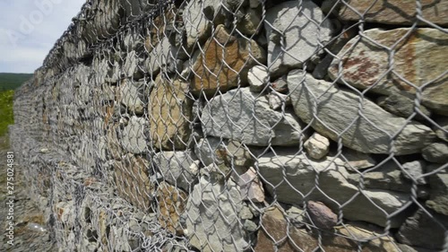 Roadside of mountain road stone gabion retaining wall prevents slope soil erosion. Road near Luchistoye / Luchyste village on southern shore of Crimea. photo