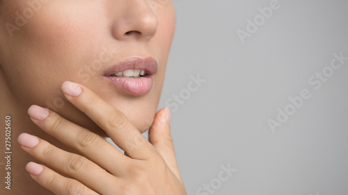 Girl with Perfect Skin and Nude Manicure Touching Chin