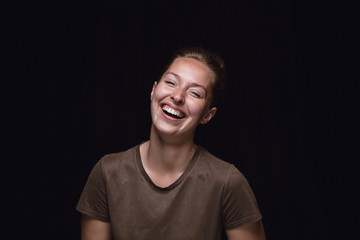 Close up portrait of young woman isolated on black studio background. Photoshot of real emotions of female model. Smiling, feeling crazy happy, laughting. Facial expression, human emotions concept.