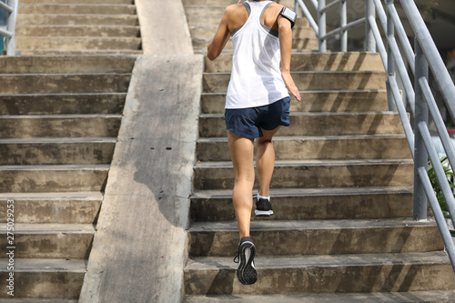 Young woman runner sportswoman running up city stairs © lzf