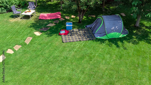 Aerial top view of campsite from above, tent and camping equipment under tree, family vacation in camp outdoors concept 