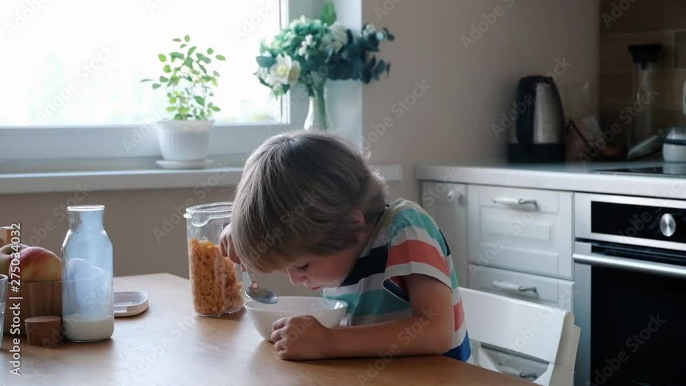 Cute boy 4 years old having breakfast cornflakes with milk at the table at home. Cute boy 4 years old having breakfast cornflakes with milk at the table at home.