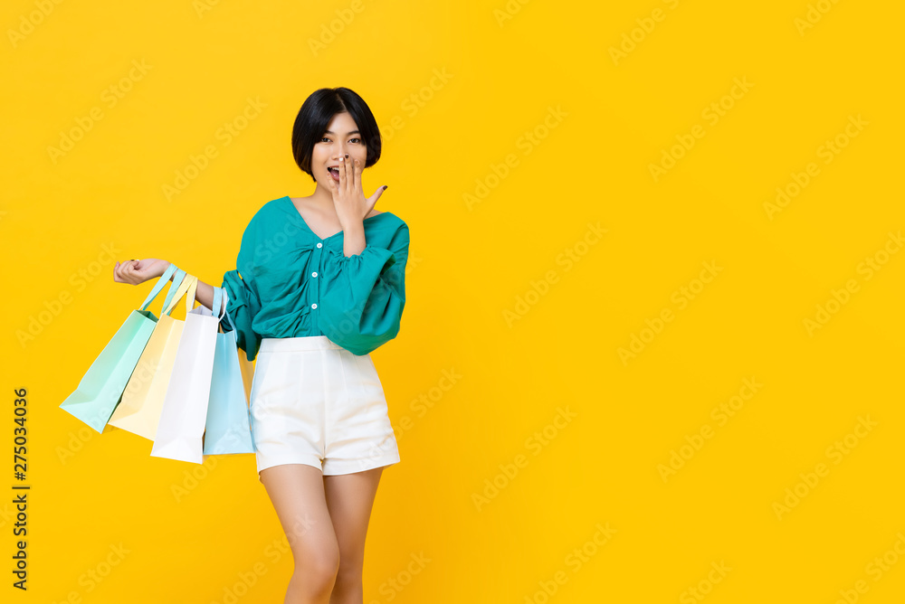 Young cheerful shopaholic Asian girl with shopping bags Young cheerful shopaholic Asian girl with shopping bags